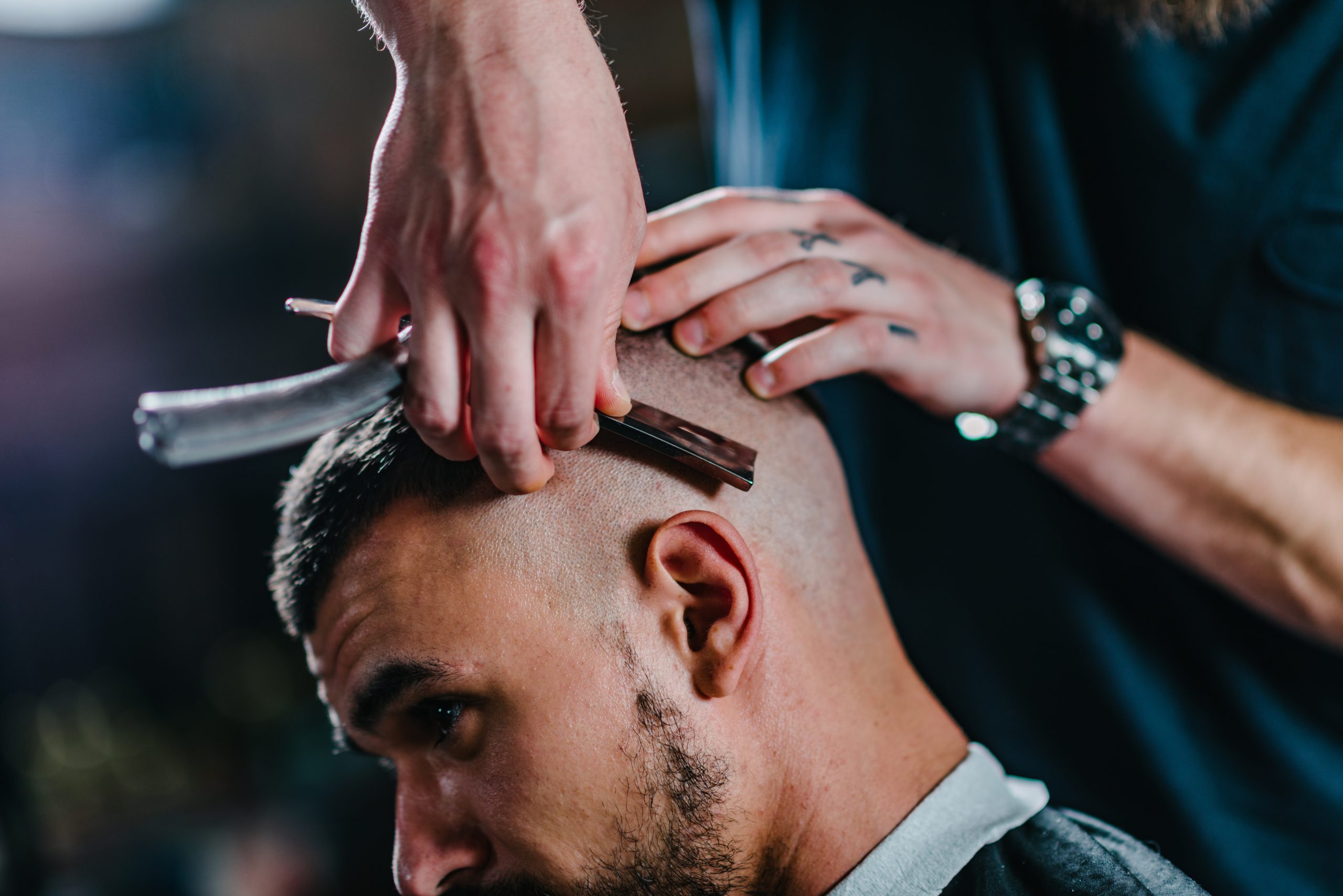 Hair styling for man in modern barbershop. Toned image